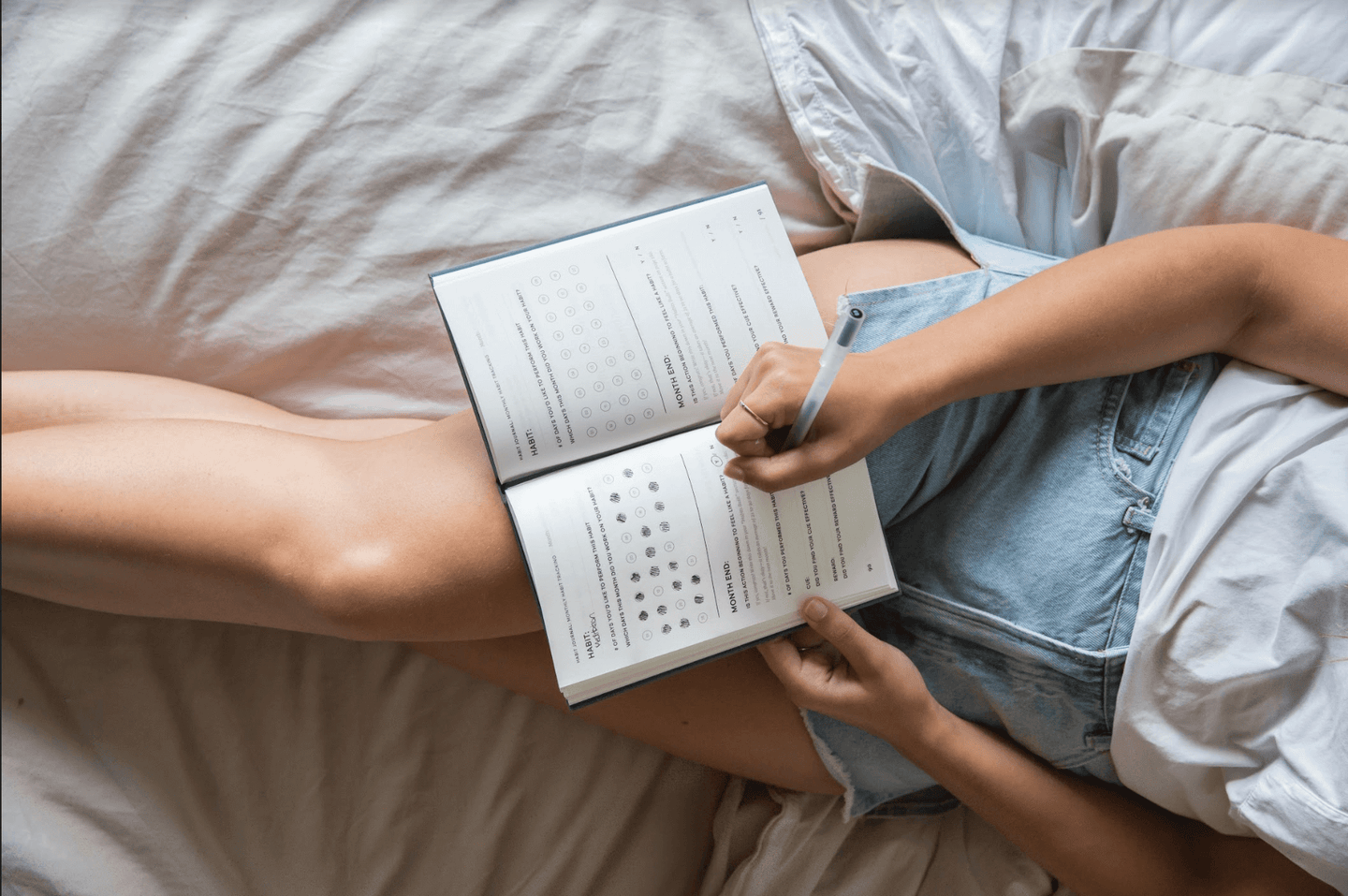 Woman writing Evergreen Journals Habit Journal